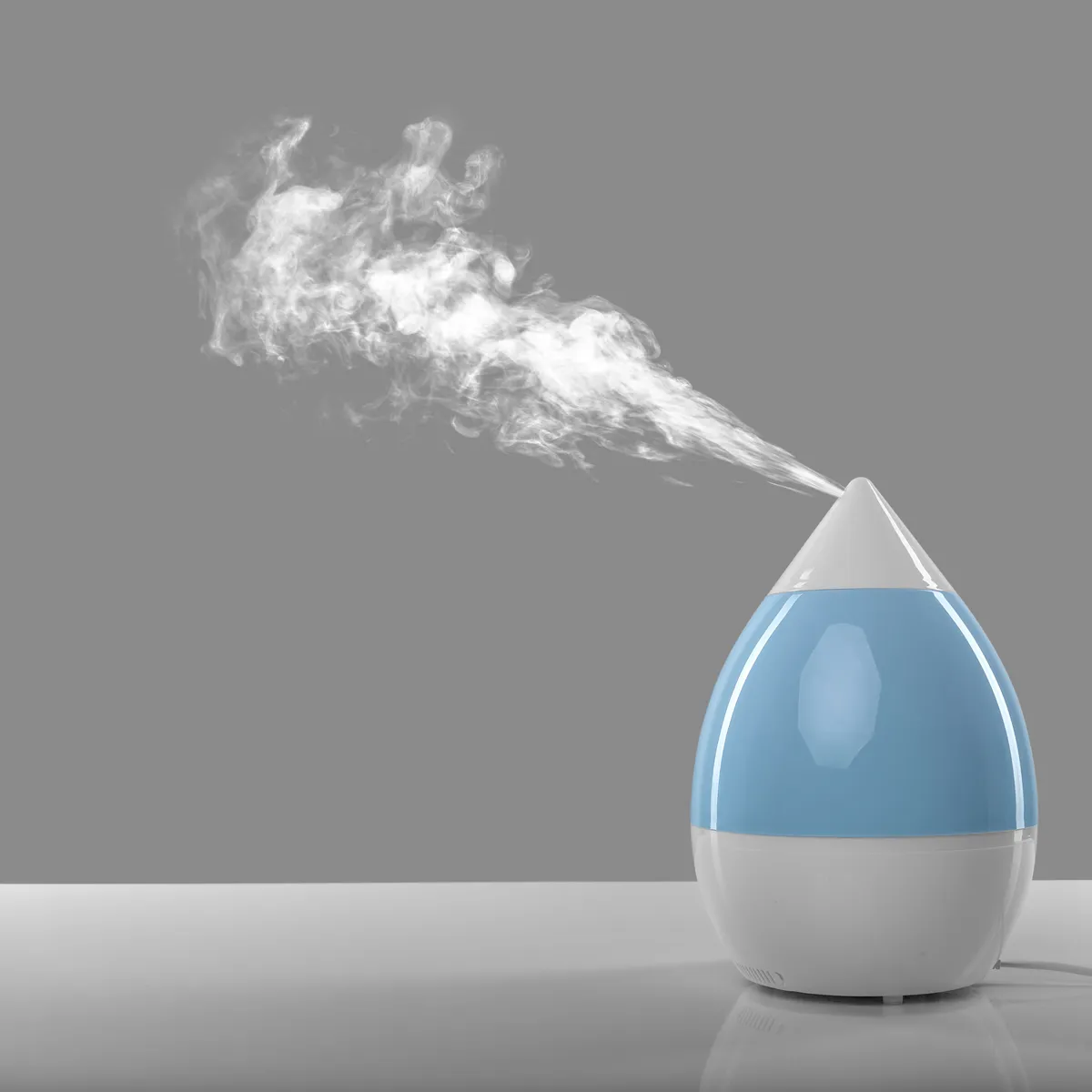 A blue and white humidifier on top of a table.